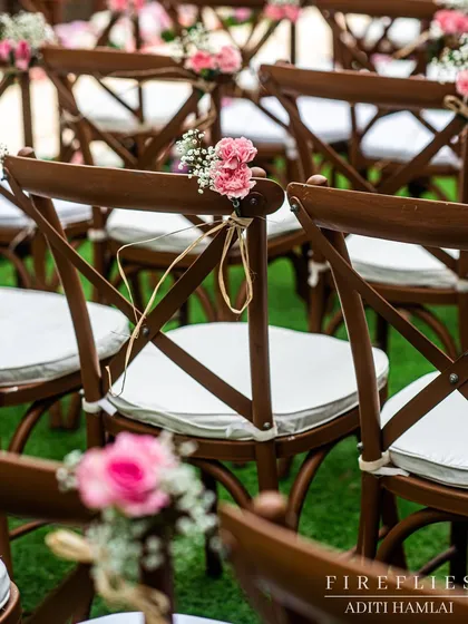 Simple yet elegant chair decor, with a small posy of pink carnations and baby's breath tied to the back of each chair.