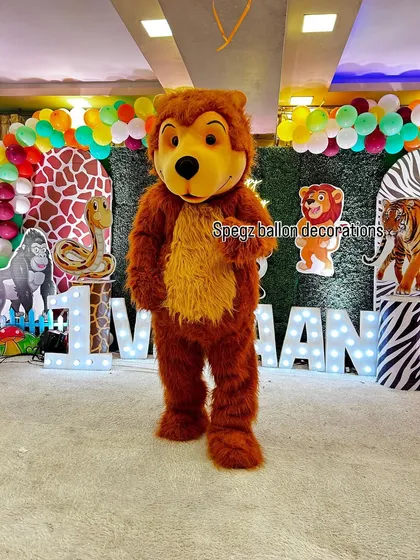 My friendly brown bear mascot posing at a jungle-themed birthday party. I can coordinate the mascot appearance to match your specific party decorations, like this safari setup, for a fully immersive experience.