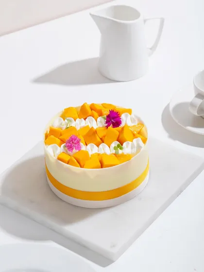 A full view of our white chocolate mango cake, a picture of simple, summery elegance.