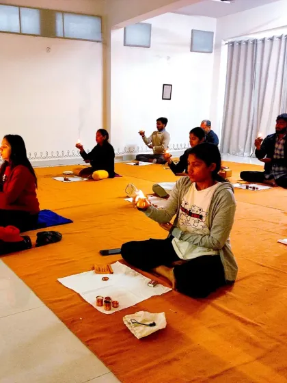 Participants hold ghee lamps during a Bhuta Shuddhi session, using the element of fire as a tool for purification.