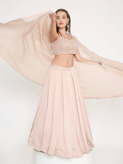 Soft, dreamy, and utterly romantic. This blush peach lehenga with a fully handworked blouse is for the bride who dreams of subtle elegance. The flowy skirt is perfect for twirling.