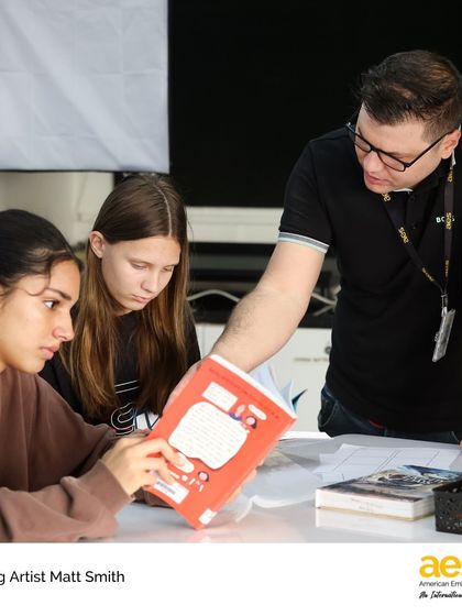 Visiting cartoonist Matt Smith reviews a student's work during a comic creation workshop. These hands-on sessions provide invaluable feedback and mentorship from a professional in the field.