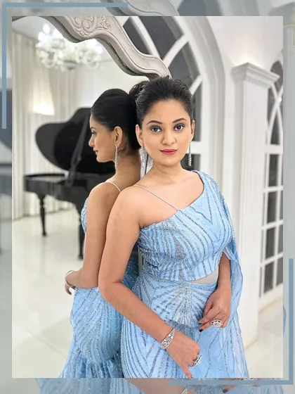 A beautiful reflection shot of the model in the ice-blue gown, highlighting its elegant design.