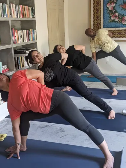The power of practicing together on a yoga retreat. Students move through a sequence of twisting lunges, supporting each other's energy and focus.