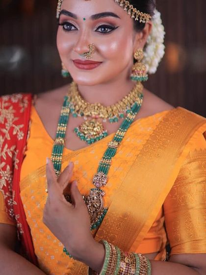 A close-up of a festive look. The bright yellow saree with a contrasting red pallu is perfect for any celebration, and the drape is kept neat to highlight the beautiful colours.