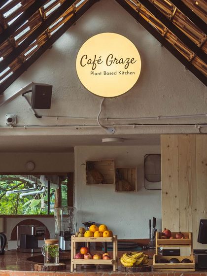 The warm glow of our Cafe Graze sign at the counter. Behind this counter, we blend smoothies, press fresh juices, and prepare meals using only the freshest, organic, and seasonal ingredients.