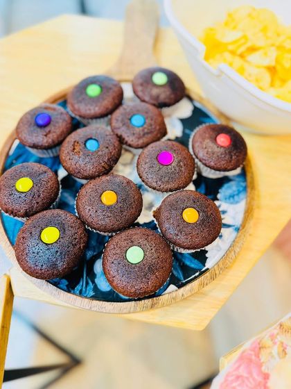 Colorful chocolate cupcakes topped with candy gems, arranged on a decorative platter. These sweet treats were a huge hit with our little guests during the tea party.