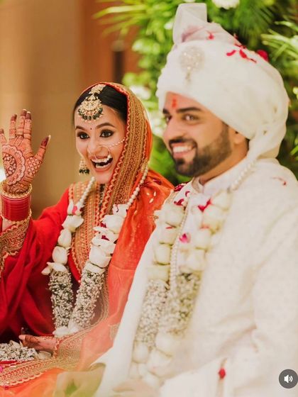 A candid, happy moment from the wedding ceremony. The bride's traditional bun stays perfectly in place, even with the weight of the dupatta.