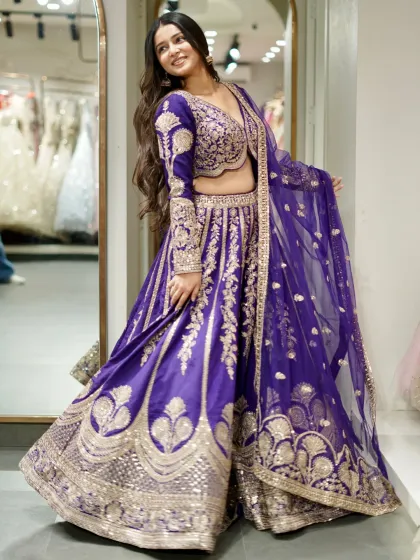 A majestic purple lehenga with intricate silver embroidery. The color is rich and royal, perfect for making a statement at an evening celebration.