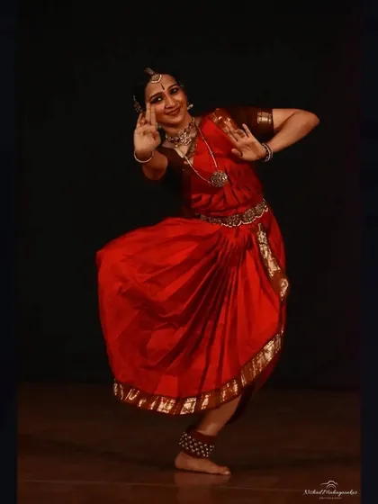 A classic pose from a solo performance, showcasing the intricate hand gestures and expressive face that are central to storytelling in Bharatanatyam.