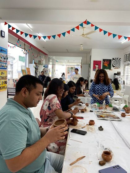 A bustling pottery workshop in session. It's a fantastic group activity where everyone can get their hands dirty and create something unique.