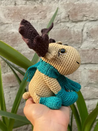 The side view of the moose amigurumi shows off his antlers and fringed scarf. He was a very fun and detailed project to work on.