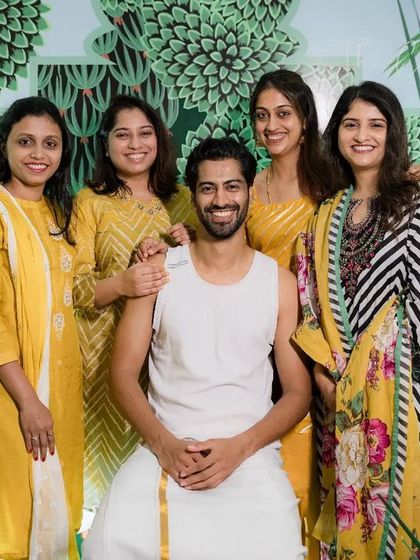 A beautiful group photo with the groom and his loved ones. The elegant green and white decor adds a touch of sophistication to the joyful occasion.