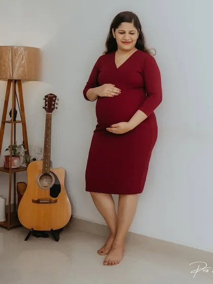 A beautiful solo portrait of the expecting mother in her home. Standing next to a guitar, this shot incorporates personal elements of her life, adding a layer of storytelling to her maternity photos.