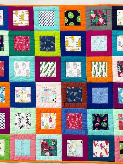 A full view of the vibrant "I-Spy" style baby quilt, perfect for engaging a little one with its variety of colors and patterns.