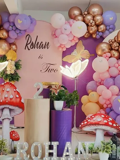 An elaborate butterfly and mushroom themed party for Rohan's second birthday. The setup uses a mix of metallic and pastel balloons, along with multiple light-up props.
