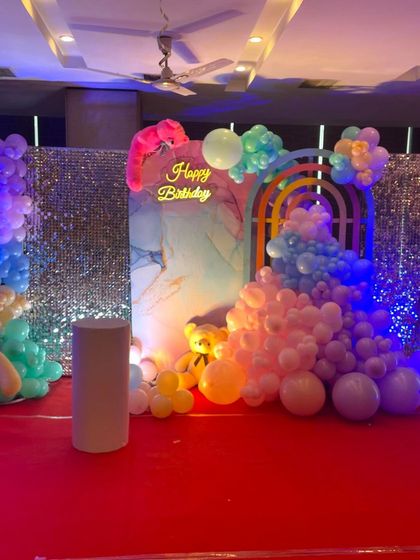 A dreamy teddy bear theme with a pastel rainbow and shimmer wall. This large stage setup includes multiple backdrops, teddy bears, and a neon sign.
