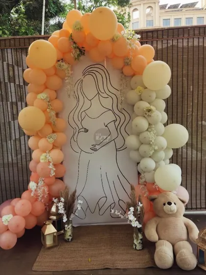 This custom backdrop is one of our favorite ways to personalize a baby shower. We created a beautiful line-art illustration of the mom-to-be, framed by a soft peach and white balloon arch and a cuddly teddy bear, making for a truly unique and sentimental photo opportunity.