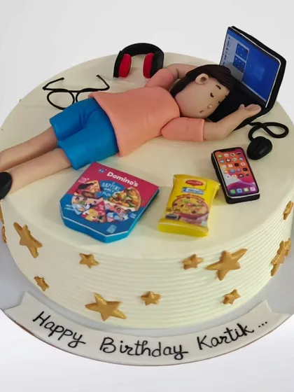 Another take on the workaholic theme, this cake shows a figure sleeping on his laptop. It's a relatable and funny cake for someone who works hard and loves their downtime with Domino's and Maggi.
