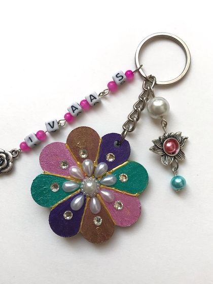 I love making these personalised keychains with extra flair. This one has a hand-painted flower base, a beaded name chain, and multiple charms like a pearl and a little rose for a layered look.