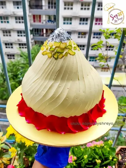For Ganesh Chaturthi, I created this special Modak-shaped cake. The entire structure is sculpted to resemble the traditional sweet, complete with pistachio garnish and silver leaf (vark), offering a festive and unique way to celebrate.