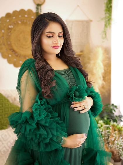 A beautiful close-up in our boho studio. The focus is on the mother-to-be's serene expression and the gorgeous details of her hair and the green ruffled gown.