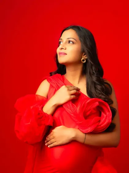 A close-up portrait in our red one-shoulder gown, showing off the intricate floral detail on the shoulder.
