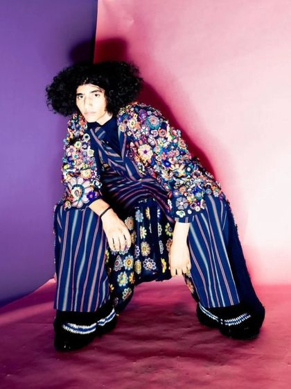 A powerful shot from a péro brand lookbook, featuring a full, natural afro style. The goal was to embrace and enhance the model's natural hair texture to complement the vibrant, layered outfit.