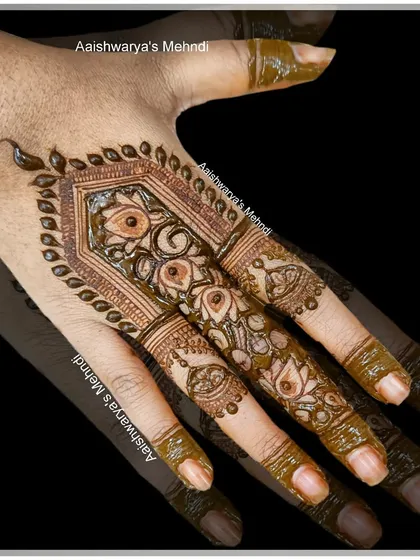 A close-up of the intricate finger design, showing the detailed floral and architectural patterns.