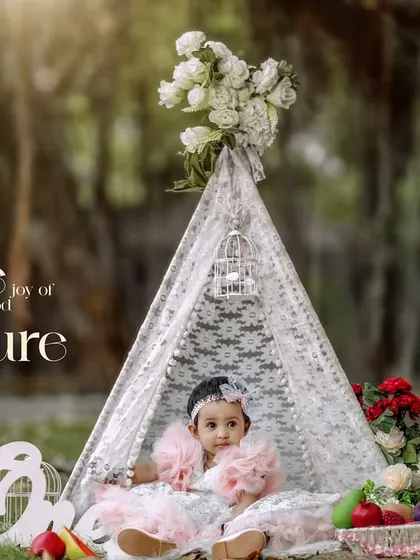 The joy of childhood captured. A sweet baby girl in a pink dress enjoys the outdoors in our lovely lace teepee setup.