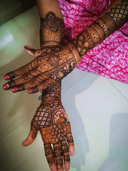 This design combines different elements, including a peacock on one hand and geometric blocks on the other. It's a great example of how we can mix and match motifs for a personalized bridal look.