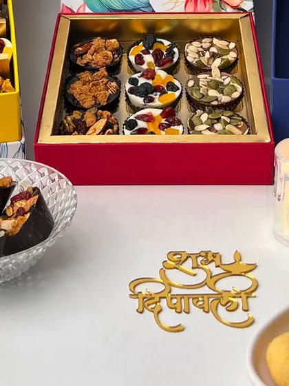 Our festive treats beautifully arranged for Diwali. This shot showcases our assorted chocolate cups alongside a "Shubh Deepawali" acrylic sign, highlighting the festive spirit of our offerings.
