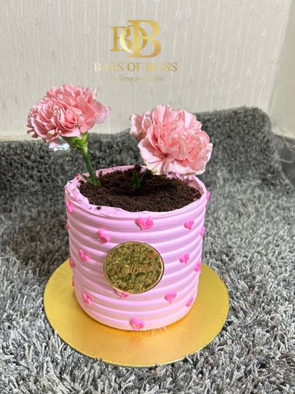 A unique flower pot cake for Mother's Day, where the "soil" is made of cookie crumbs and real flowers are planted on top.