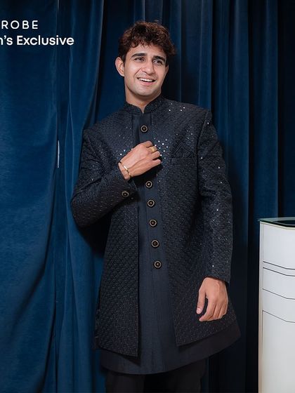 A smiling client in our black quilted Indo-western sherwani. The subtle sparkle and modern design make it a versatile choice for any celebration.