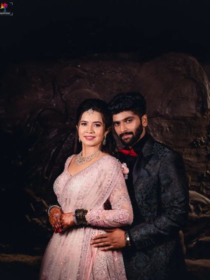 A classic reception portrait against a textured, dark background. The couple's pose is elegant and timeless, perfect for a formal wedding album.