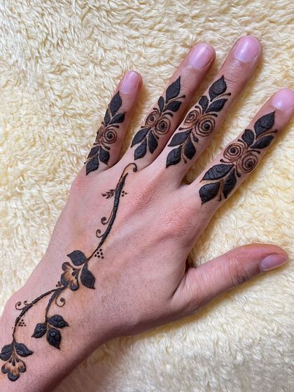 A beautiful design with a vine of roses and leaves on the fingers, connected to a delicate vine on the back of the hand.