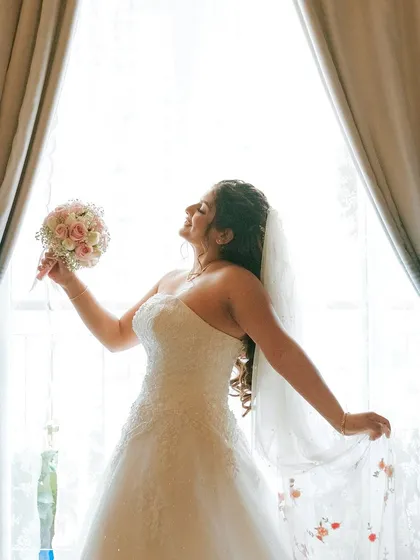 A duplicate of image 80, this shot captures the bride's pure joy as she soaks in the moment, her radiant makeup glowing in the light.