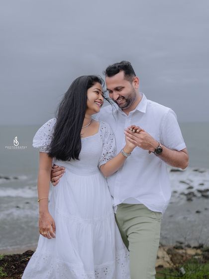 A sweet moment of holding hands and sharing a smile. The focus is entirely on their interaction, creating a timeless and romantic image.