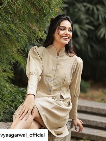Actress Divya Agarwal smiling in our structured jute linen tunic dress. This versatile piece, with its high neck and puff sleeves, can be styled for a casual day out or a more formal event.