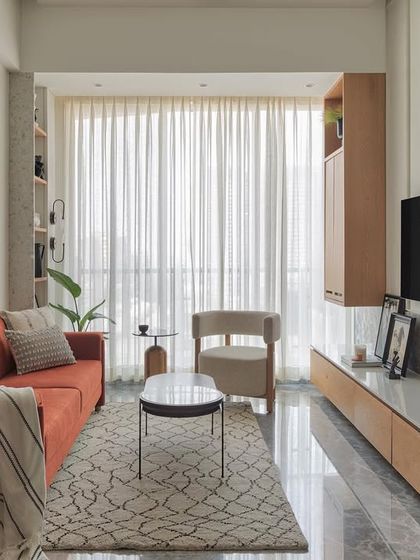 This cozy living room corner is perfect for unwinding. The rust-colored sofa adds a pop of warmth, while the terrazzo shelves filled with curated artifacts bring personality and character to this contemporary home interior.