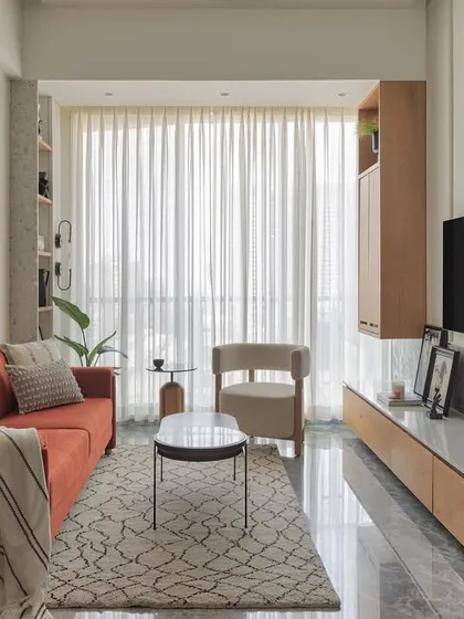 This cozy living room corner is perfect for unwinding. The rust-colored sofa adds a pop of warmth, while the terrazzo shelves filled with curated artifacts bring personality and character to this contemporary home interior.