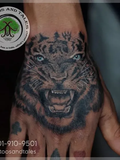 A realistic tiger tattoo, placed right on the hand. This kind of detailed black and grey work in a high-motion area requires precision and expertise to ensure it heals and lasts beautifully.