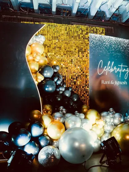 This modern backdrop combines a gold shimmer wall with an organic balloon garland in metallic tones. It's a versatile setup that works well for product launches, company parties, or award night photo booths, offering a touch of glamour.