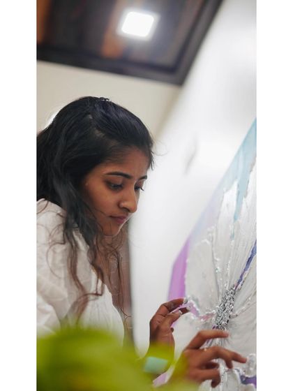 A close-up shot of me carefully placing silver leaf onto the center of a textured flower. This delicate process adds a touch of light and elegance, completing the piece and symbolizing the inner sparkle we find through growth.