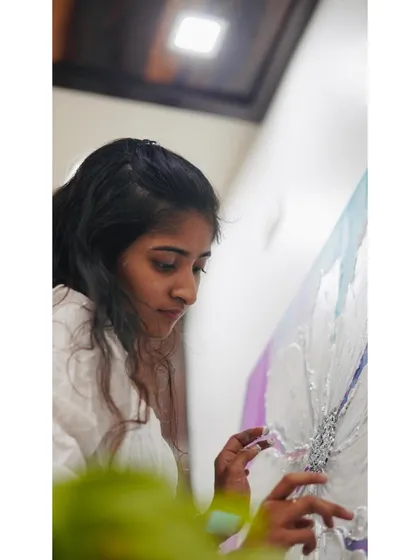 A close-up shot of me carefully placing silver leaf onto the center of a textured flower. This delicate process adds a touch of light and elegance, completing the piece and symbolizing the inner sparkle we find through growth.