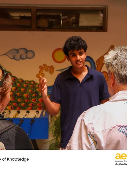 A student passionately explains his TOK project to community members. These presentations build confidence and communication skills, which are essential for university interviews and academic success.
