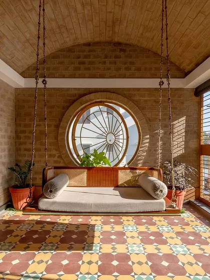 The full view of the swing, vaulted ceiling, and circular window.