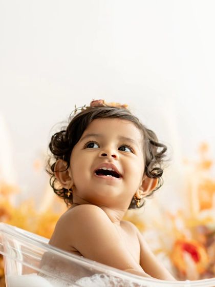 A close-up of this little one's joyful expression during her autumn-themed tub bath.