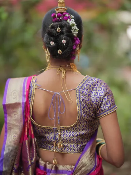 Another view of the traditional 'khopa' hairstyle, showing the neatness of the bun and the placement of the floral decorations.