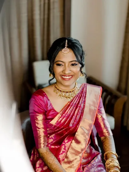 A series of photos capturing the grace of this South Indian bride. Her look features traditional temple jewelry, a silk saree, and a fresh, dewy makeup finish with a classic floral hair bun, embodying timeless elegance.